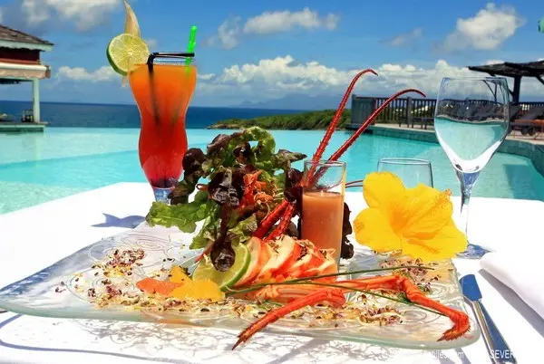 Table de fruits de mer et spécialités créoles servie face à la mer en Guadeloupe