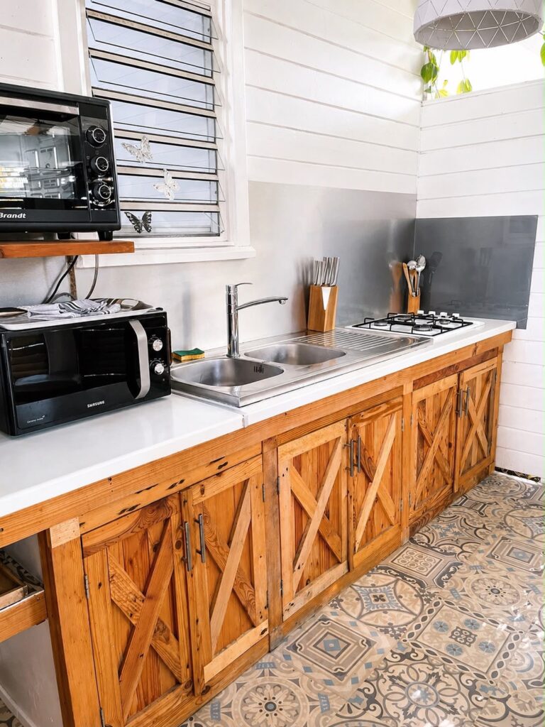 Cuisine équipée avec évier double, plaques de cuisson et rangements en bois du gîte Bois Patate, Les Bois d'Orée