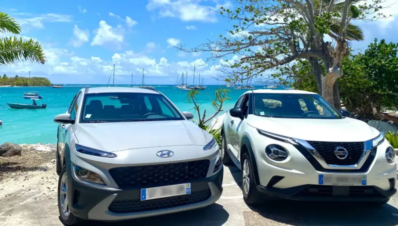 Voiture stationnée au cœur d’un paysage tropical verdoyant en Guadeloupe