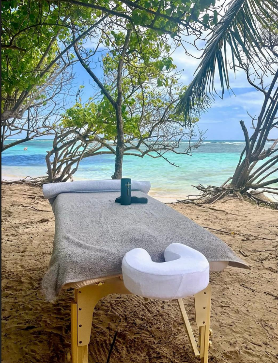 Table de massage installée sur une plage de Guadeloupe face à la mer
