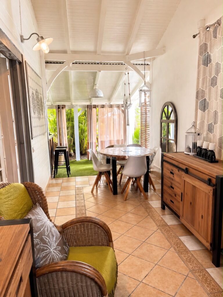 Salon et coin repas chaleureux avec table ronde en bois du gîte Bois Patate, Les Bois d'Orée